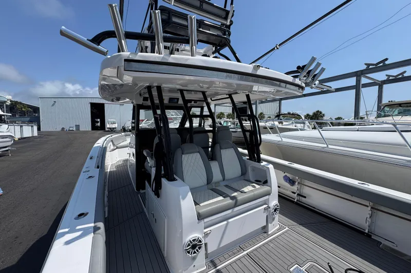 Slide: The Image of 2022 Everglades 395 Center Console boat with seating and rod holders, docked outdoors. - 31