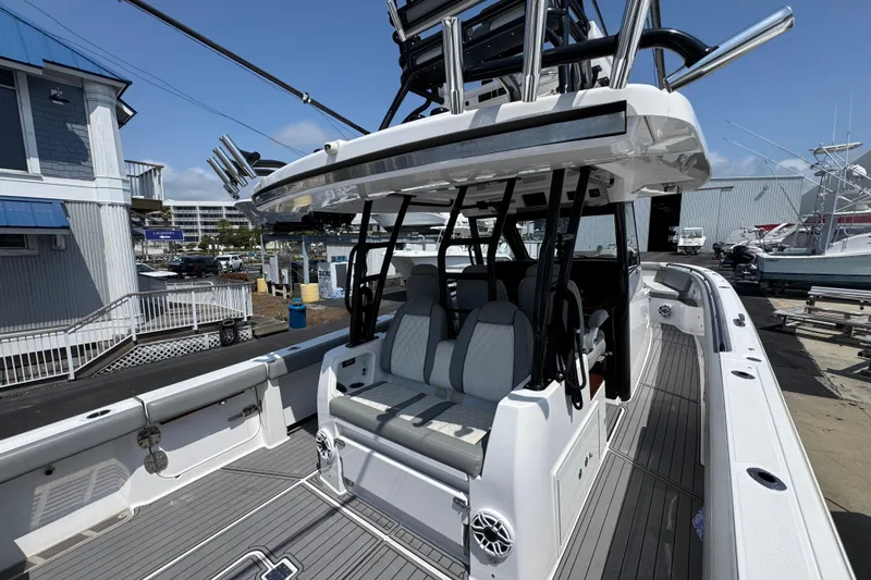 Slide: The Image of 2022 Everglades 395 Center Console boat docked at a marina, showcasing seating and helm. - 34