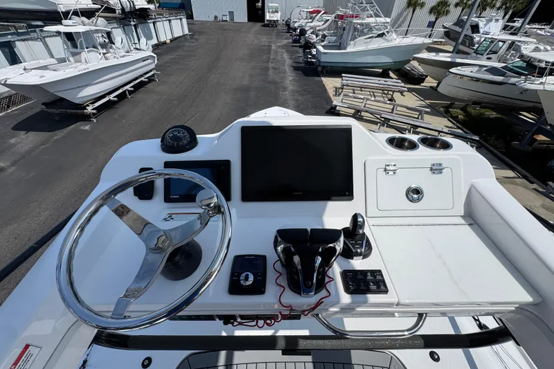Slide: The Image of 2022 Everglades 395 Center Console boat dashboard with steering wheel and navigation screen. - 35
