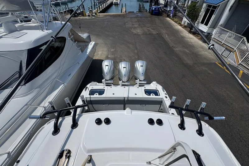 Slide: The Image of 2022 Everglades 395 Center Console boat with triple engines at a marina dock. - 40