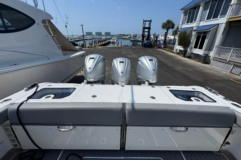 Slide: The Image of 2022 Everglades 395 Center Console boat with triple outboard engines at a marina. - 42