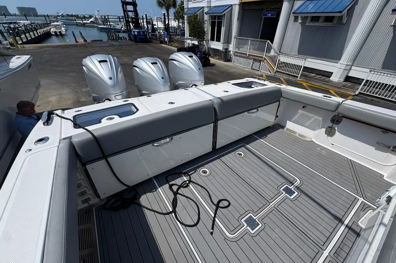 Slide: The Image of 2022 Everglades 395 Center Console boat with triple outboard engines at a marina. - 43