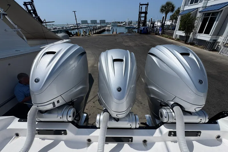 Slide: The Image of Three powerful outboard motors on a 2022 Everglades 395 Center Console boat at a marina. - 44