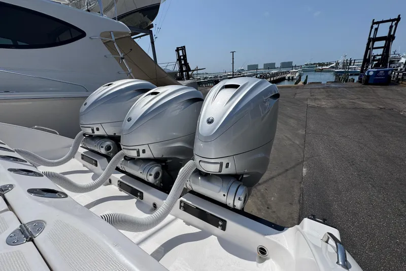 Slide: The Image of Triple outboard motors on a 2022 Everglades 395 Center Console boat at a marina. - 45