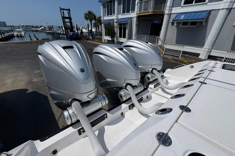 Slide: The Image of Triple outboard engines on a 2022 Everglades 395 Center Console boat at a marina. - 46