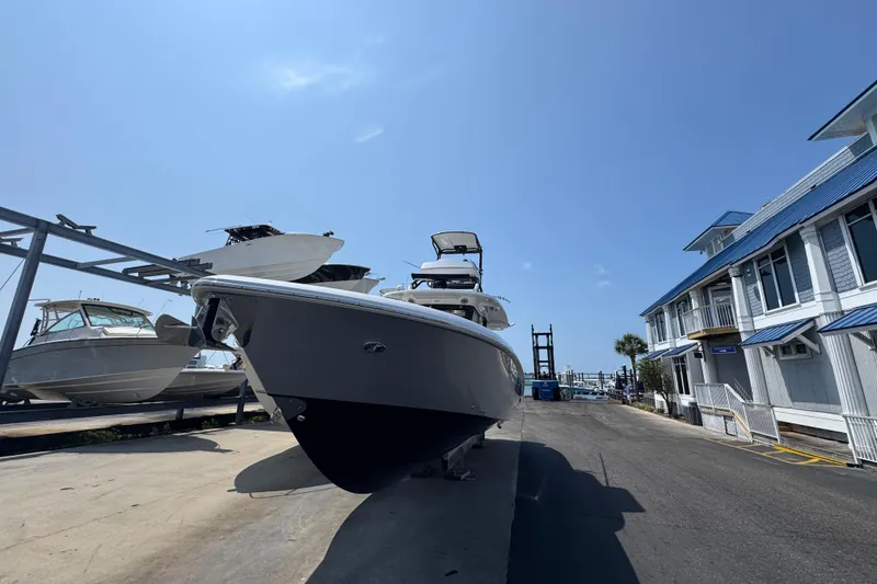 Slide: The Image of 2022 Everglades 395 Center Console boat on dry dock under clear blue sky. - 5