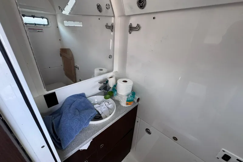 Slide: The Image of Interior of 2022 Everglades 395 Center Console boat bathroom with sink and toiletries. - 50