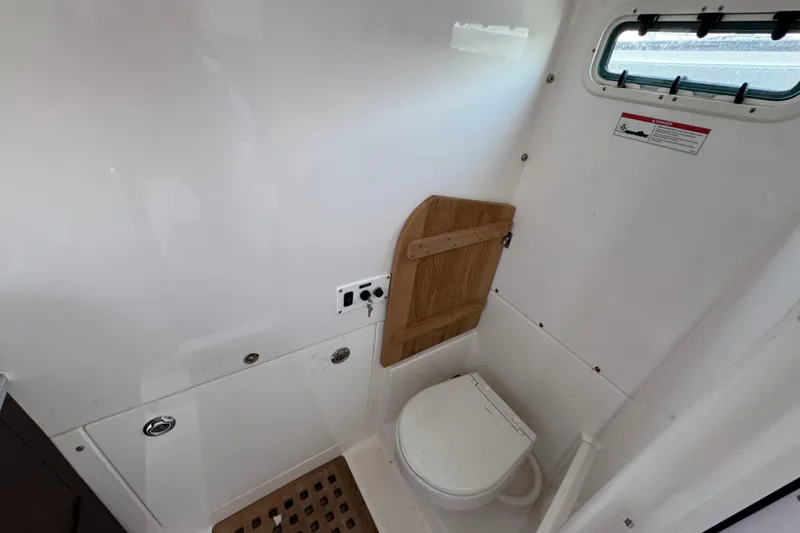 Slide: The Image of Interior of 2022 Everglades 395 Center Console boat bathroom with toilet and window. - 51