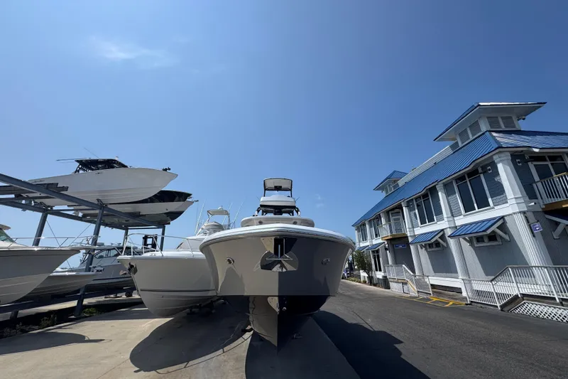 Slide: The Image of 2022 Everglades 395 Center Console boat docked near a marina building under clear blue sky. - 6