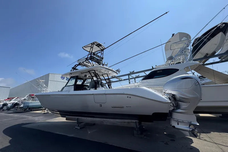 Slide: The Image of 2022 Everglades 395 Center Console boat with triple outboard engines, docked outdoors. - 9