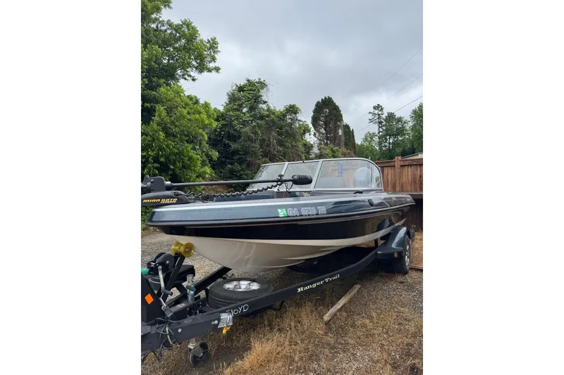 The Image of 2013 Ranger 1850 LS boat on trailer, parked outdoors with trees in background. - 1