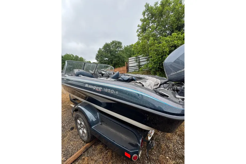 Slide: The Image of 2013 Ranger 1850 LS boat on trailer, parked outdoors near trees. - 8