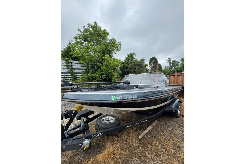 Slide: The Image of 2013 Ranger 1850 LS boat on trailer, parked outdoors with trees in background. - 9