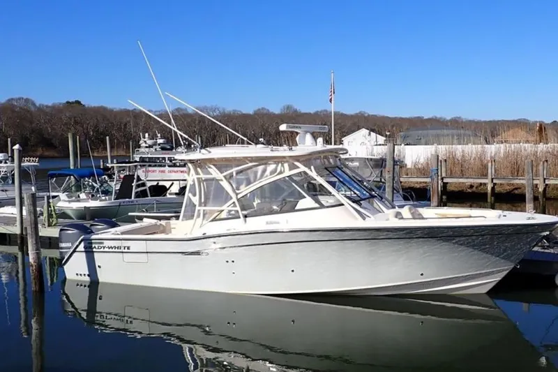 The Image of 2016 Grady-White Freedom 335 boat docked at marina under clear blue sky. - 1