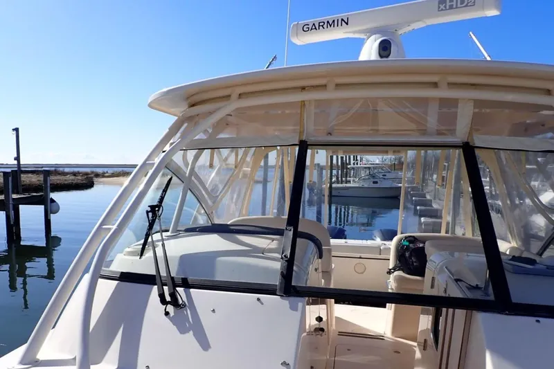 Slide: The Image of 2016 Grady-White Freedom 335 boat docked, featuring Garmin radar and clear skies. - 11
