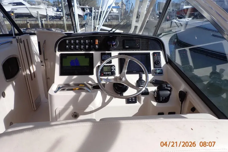 Slide: The Image of Helm of 2016 Grady-White Freedom 335 boat with navigation equipment and steering wheel. - 19