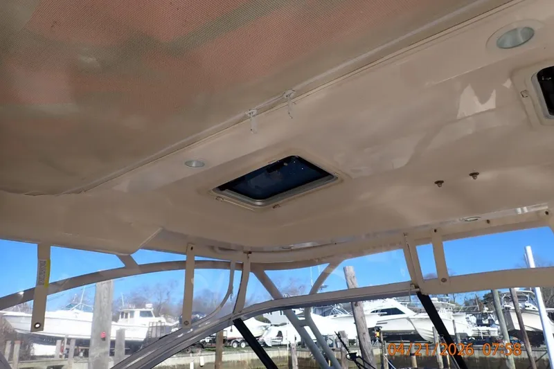 Slide: The Image of Interior view of 2016 Grady-White Freedom 335 boat with open hatch and marina background. - 20
