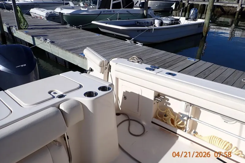 Slide: The Image of 2016 Grady-White Freedom 335 boat docked, featuring seating and storage compartments. - 27