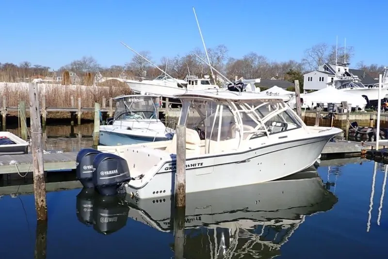 Slide: The Image of 2016 Grady-White Freedom 335 boat docked with Yamaha engines, clear blue sky. - 3