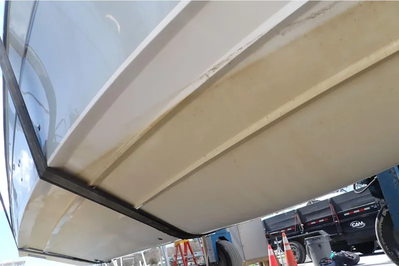 Slide: The Image of 2016 Grady-White Freedom 335 boat hull, viewed from below, in a maintenance area. - 30