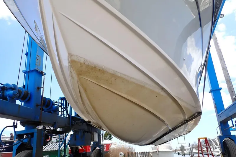 Slide: The Image of 2016 Grady-White Freedom 335 boat hull on lift, showcasing underside details. - 32