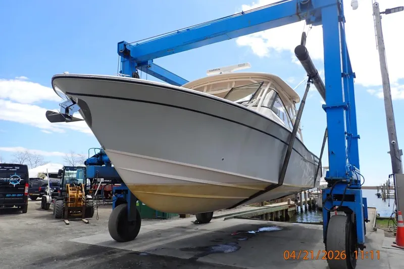 Slide: The Image of 2016 Grady-White Freedom 335 boat lifted by crane at marina. - 5