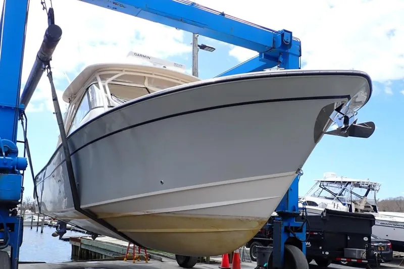 Slide: The Image of 2016 Grady-White Freedom 335 boat on lift at marina, side view. - 7