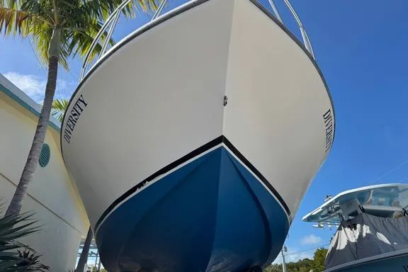 Slide: The Image of 1996 Island Hopper Forward Cabin Dive Boat, docked under a clear blue sky. - 4