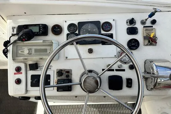 Slide: The Image of 1996 Island Hopper Forward Cabin Dive Boat dashboard with steering wheel and control instruments. - 7