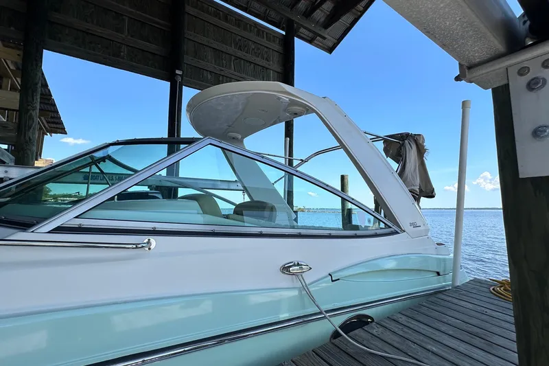 Slide: The Image of 2014 Monterey 260 Sport Yacht docked under a wooden shelter by the water. - 14