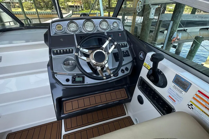 Slide: The Image of Helm of 2014 Monterey 260 Sport Yacht with modern controls and wood accents. - 19
