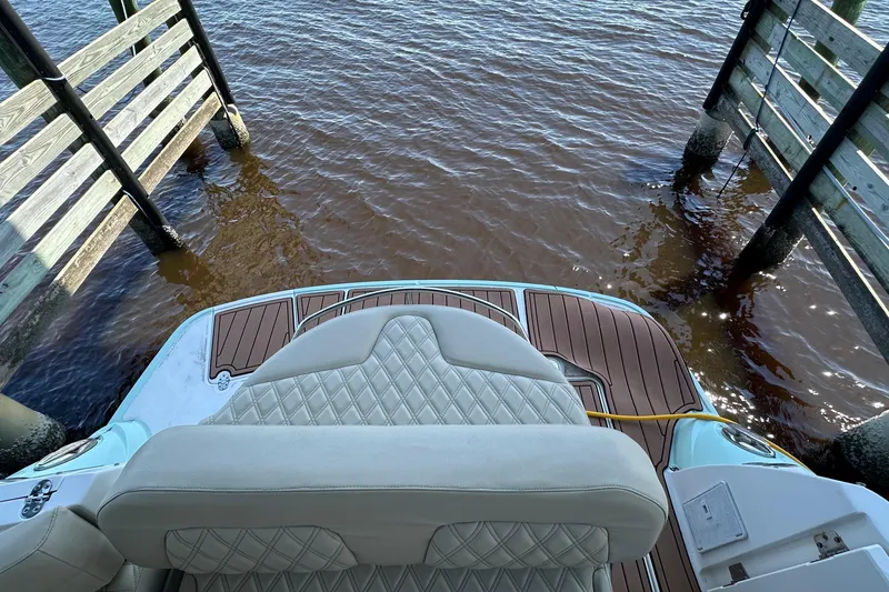 Slide: The Image of 2014 Monterey 260 Sport Yacht at dock, featuring cushioned seating and wooden deck. - 22
