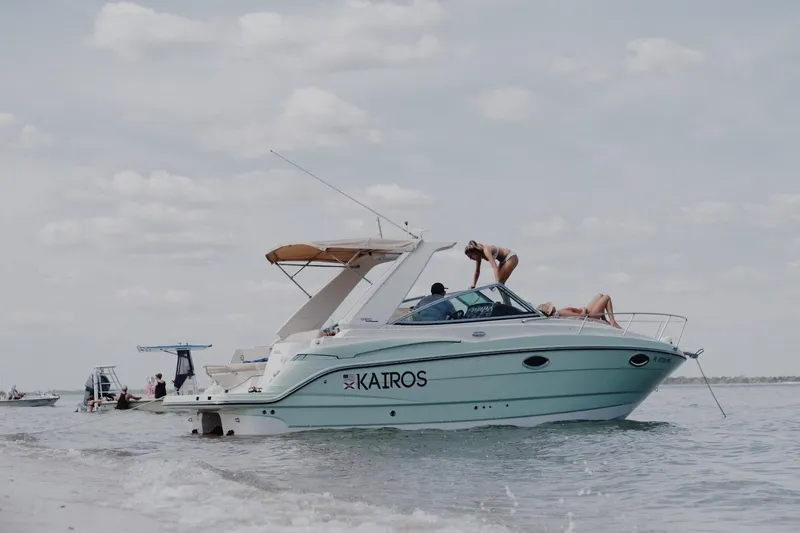 The Image of 2014 Monterey 260 Sport Yacht anchored on a sunny beach day with people relaxing onboard. - 6