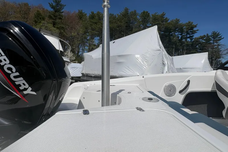 Slide: The Image of 2022 Tahoe 185 S boat with Mercury engine, parked outdoors, wrapped boats in background. - 8