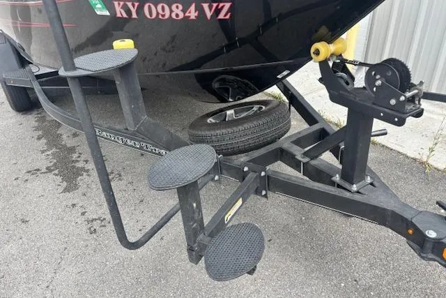 Slide: The Image of Trailer steps and winch of 2023 Ranger VX1888 WT boat on pavement. - 2