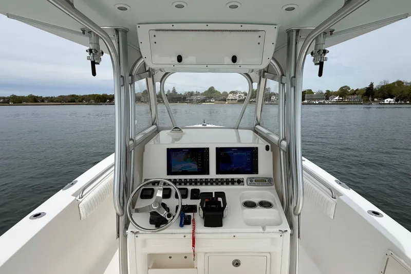 Slide: The Image of 2007 Sea Hunt Gamefish 29 boat console with dual screens on calm water. - 13