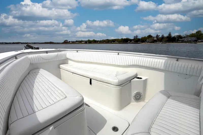 Slide: The Image of 2007 Sea Hunt Gamefish 29 boat interior with white seating, on a calm waterway. - 17