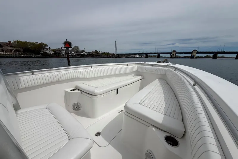 Slide: The Image of 2007 Sea Hunt Gamefish 29 boat interior with white seating, docked near a bridge. - 19