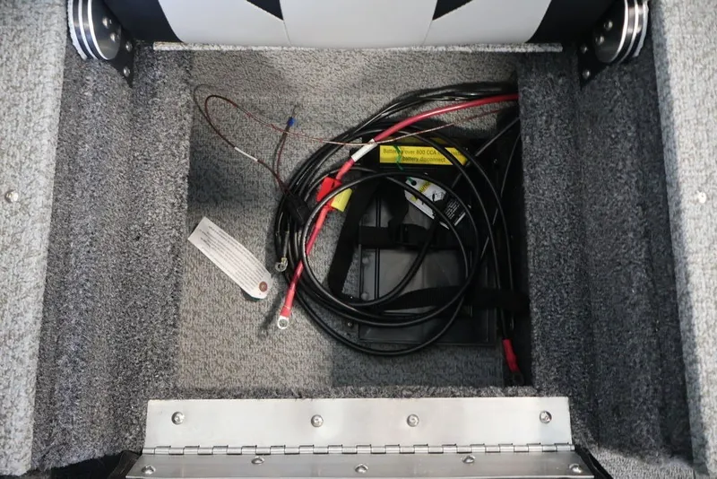 Slide: The Image of Battery compartment of 2026 Crestliner 1750 Fish Hawk SC boat, featuring wiring and carpeted interior. - 24
