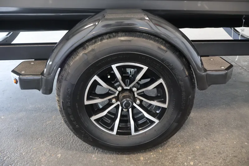 Slide: The Image of Trailer wheel of 2026 Crestliner 1750 Fish Hawk SC boat, featuring black alloy rim. - 44