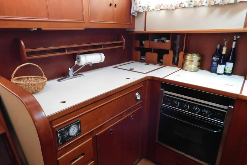 Slide: The Image of 1986 Grand Banks 46 Classic yacht kitchen with wood cabinetry and modern appliances. - 12