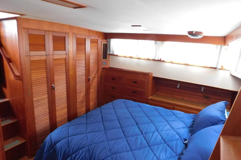 Slide: The Image of Cozy bedroom in 1986 Grand Banks 46 Classic yacht with wood paneling and blue bedding. - 14