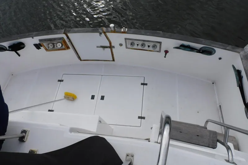 Slide: The Image of 1986 Grand Banks 46 Classic boat deck with storage compartments and cleaning brush. - 22