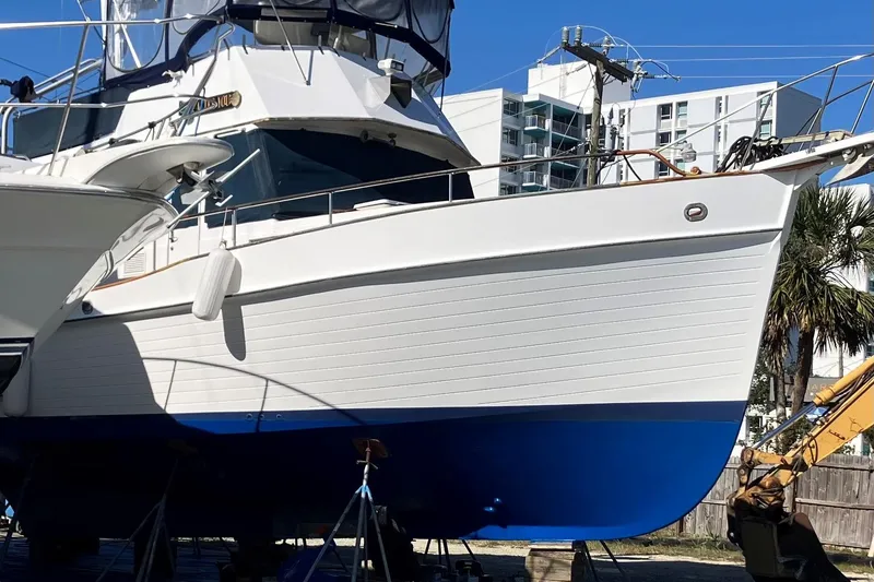 Slide: The Image of 1986 Grand Banks 46 Classic yacht on dry dock, white hull with blue bottom, urban background. - 27