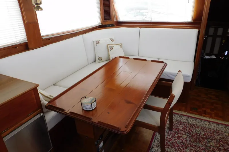 Slide: The Image of Interior of 1986 Grand Banks 46 Classic yacht with wooden table and white seating. - 8
