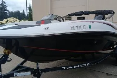 The Image of 2024 Tahoe T16 boat on trailer, black and white design, parked outdoors. - 0