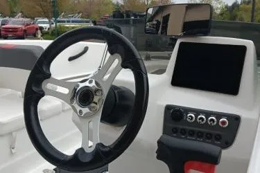 Slide: The Image of 2024 Tahoe T16 boat dashboard with steering wheel and control panel. - 2