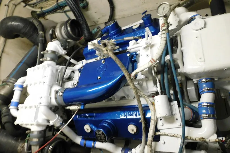 Slide: The Image of Engine room of a 1987 Hatteras 54 Motor Yacht, featuring blue and white components. - 42