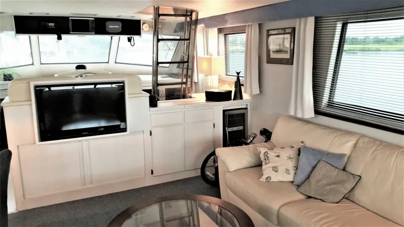 Slide: The Image of Interior of 1987 Hatteras 54 Motoryacht with sofa, TV, and windows. - 6