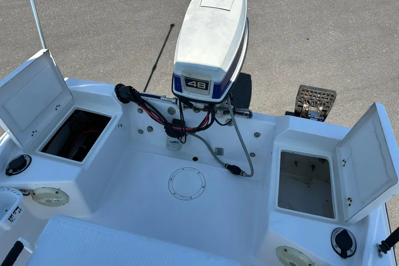 Slide: The Image of 1996 Wellcraft 160 Fisherman boat with open storage compartments and outboard motor. - 15